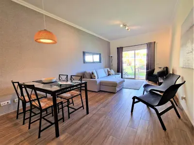 a living room with a table and chairs and a couch at Albufeira Prime Apartment in Albufeira