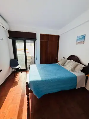 a bedroom with a bed with a blue blanket at Apartment Old Town Ferreira de Castro in Albufeira