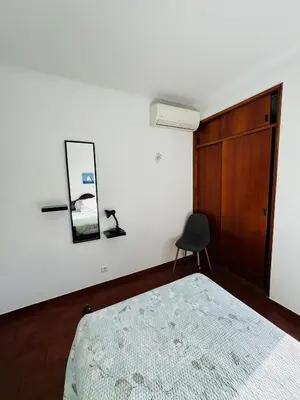 a bedroom with a bed and a chair and a mirror at Apartment Old Town Ferreira de Castro in Albufeira