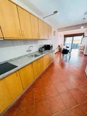 a kitchen with wooden cabinets and a tile floor at Apartment Old Town Ferreira de Castro in Albufeira