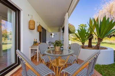 a patio with a glass table and chairs at Victory Beach House in Quinta do Lago