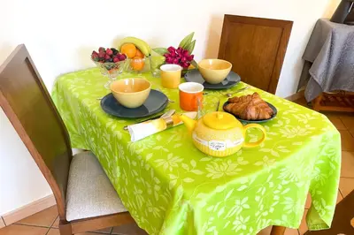 a table with a green table cloth with food on it at VILLA EBER - independent 1 & 2 bedroom apartments, pool, air con, fast Wi-Fi, near old town of Albufeira and beaches in Albufeira