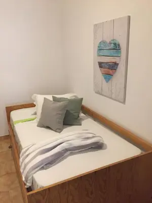 a bed in a room with a heart painting on the wall at Apartment Sea View 20m to beach - TOP Quarteira ALGARVE in Quarteira
