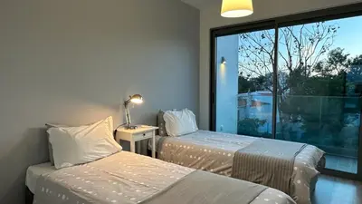 two beds in a room with a large window at Albuhera - Private Pool - 8 Pax - Albufeira in Albufeira