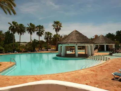a swimming pool with a gazebo and palm trees at Luxury 2 Bedroom Apartment with Private Garden in Almancil