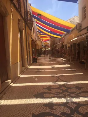 a street with colorful umbrellas hanging over a street at Luxury 2 Bedroom Apartment with Private Garden in Almancil
