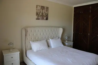 a bedroom with a white bed with two white pillows at Luxury 2 Bedroom Apartment with Private Garden in Almancil