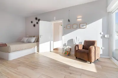 a bedroom with a bed and a chair at Natural Grey Albufeira in Albufeira