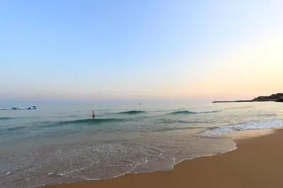 a person standing in the water at the beach at Natural Grey Albufeira in Albufeira
