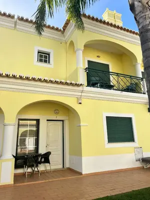 a yellow house with a balcony and a patio at Rockfield 4 in Albufeira