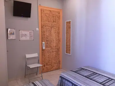 a room with a door and a chair and a bed at Guest House Sao Filipe in Faro