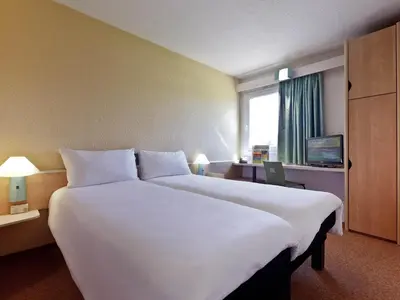 a large white bed in a hotel room at Hotel ibis Faro Algarve in Faro