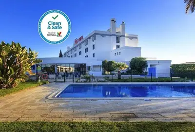 a restaurant with a large screen on the wall at Hotel ibis Faro Algarve in Faro
