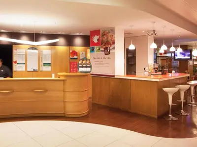 a restaurant with a bar with stools at Hotel ibis Faro Algarve in Faro