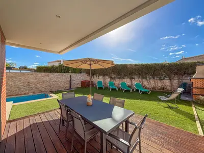 a patio with a table and chairs and an umbrella at V3, Villa Jardins Branqueira6 near Beach, Albufeira in Albufeira