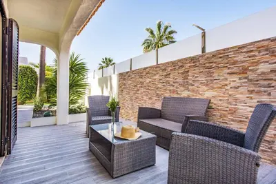 a patio with wicker furniture and a brick wall at Villa Marquesa in Guia