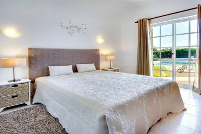 a bedroom with a large bed and a large window at Villa Licinia in Guia