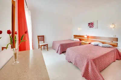 a hotel room with two beds and a table at Villa Licinia in Guia