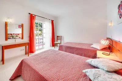 a bedroom with two beds and a desk and a window at Villa Licinia in Guia
