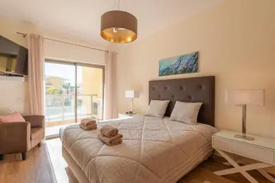 a bedroom with a bed with a teddy bear on it at Jardins Marina Stars in Albufeira