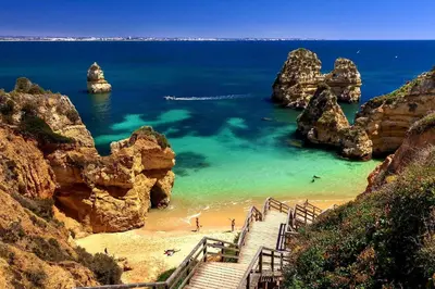 a staircase leading to a beach with rocks in the water at Jardins Marina Stars in Albufeira