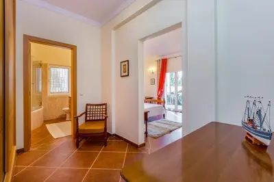 a room with a table and a chair and a bathroom at Villa Amarela in Boliqueime