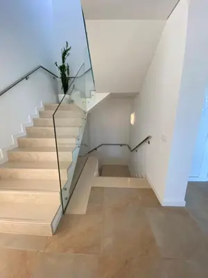 a glass staircase in a house with a potted plant at Amora Villa - Vilamoura in Vilamoura