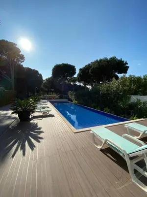 a deck with lounge chairs and a swimming pool at Amora Villa - Vilamoura in Vilamoura