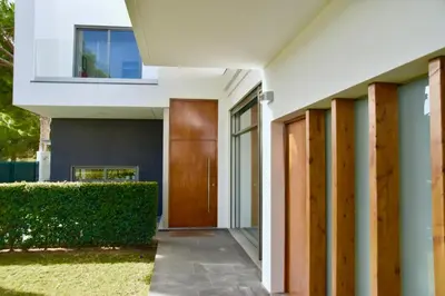 a house with a wooden door in front of it at Amora Villa - Vilamoura in Vilamoura