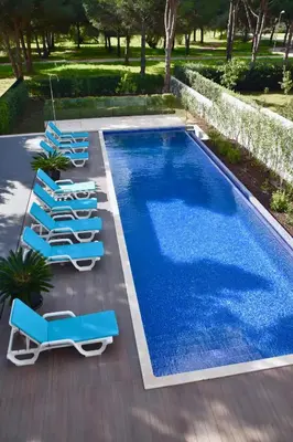 a swimming pool with blue lounge chairs and a swimming pool at Amora Villa - Vilamoura in Vilamoura