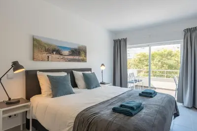 a bedroom with a large bed with blue towels on it at VERASOL 3 in Albufeira