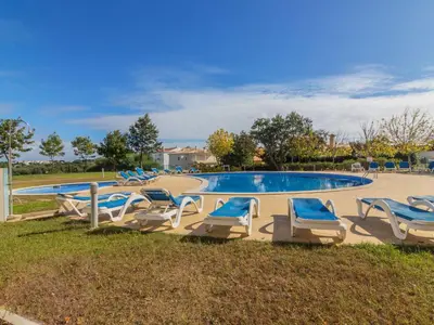 a group of lounge chairs around a swimming pool at Apartment Monte da Eira by Interhome in Brejos