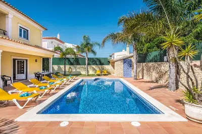 a swimming pool with lounge chairs and a villa at Villa Luana in Olhos de Água