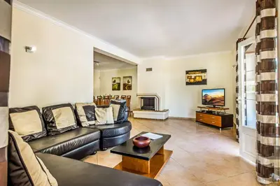 a living room with a couch and a tv at Villa Luana in Olhos de Água
