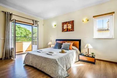 a bedroom with a large bed and a balcony at Villa Luana in Olhos de Água