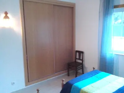 a bedroom with a large wooden closet next to a bed at Welcoming apartment in Albufeira 80 m² with shared pool in Albufeira