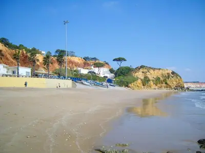 a sandy beach with a view of the ocean at Welcoming apartment in Albufeira 80 m² with shared pool in Albufeira