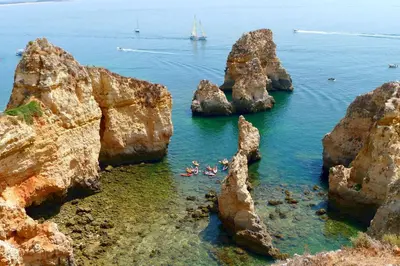 a group of people in the water near some rocks at Welcoming apartment in Albufeira 80 m² with shared pool in Albufeira