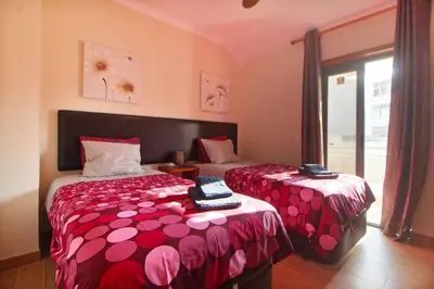 a bedroom with two beds and a window at Apt 2 Quartos, BBQ, AC, Varanda, Prestige For Home in Quarteira