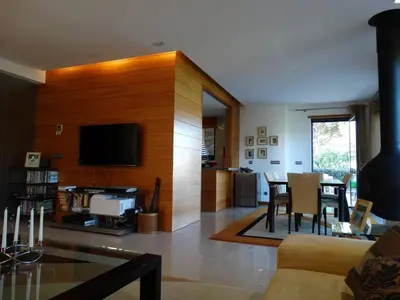a living room with a television and a table and chairs at Apartamento com 3 quartos e piscina in Vale do Lobo