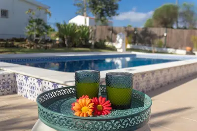 two cups and flowers on a table near a swimming pool at villa yvonne,private pool,private parking 1,7 km from the beach in Albufeira