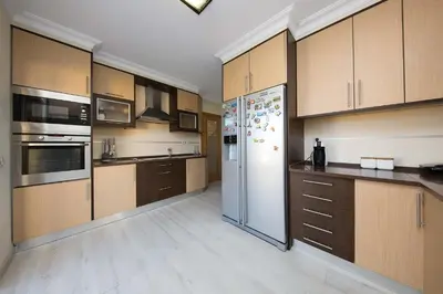 a large kitchen with wooden cabinets and a refrigerator at Villa Lote 7 by Gabi Miguel in Guia