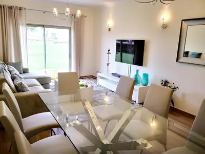 a living room with a glass table and chairs at Spacious apartment in Albufeira with pool and terrace in Albufeira
