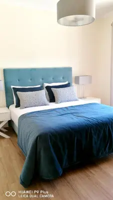 a bedroom with a large bed with a blue blanket at Spacious apartment in Albufeira with pool and terrace in Albufeira