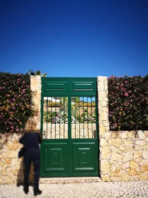 a woman standing in front of a green door at Spacious apartment in Albufeira with pool and terrace in Albufeira