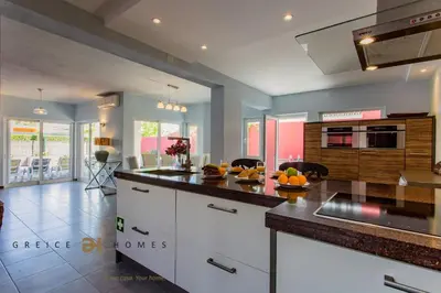 a kitchen with white cabinets and a counter top at Villa Oriente - Greice Homes in Vilamoura