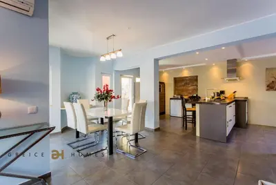 a dining room and kitchen with a table and chairs at Villa Oriente - Greice Homes in Vilamoura