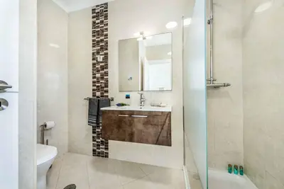 a bathroom with a sink and a toilet and a mirror at Villa Jomar in Guia