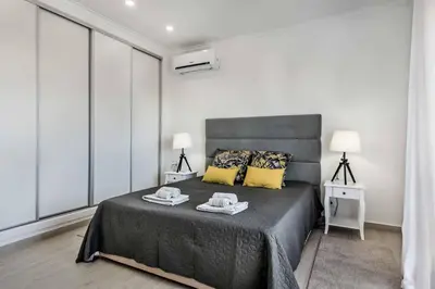 a bedroom with a large bed with yellow pillows at Villa Simoes in Guia