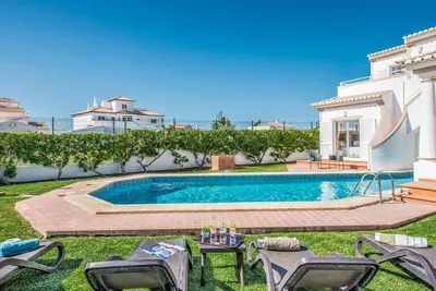 a swimming pool in the yard of a house at Villa Damara in Albufeira